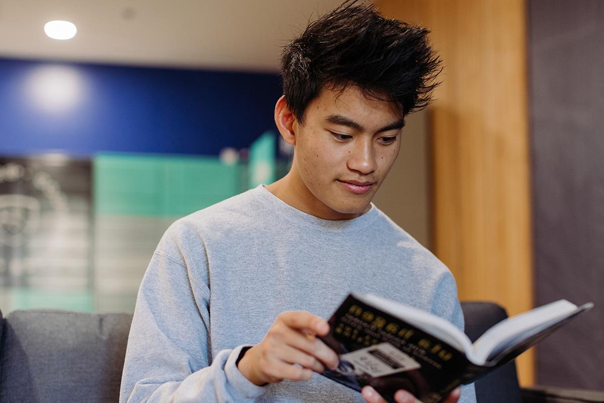 History student reads a book in the dorms.